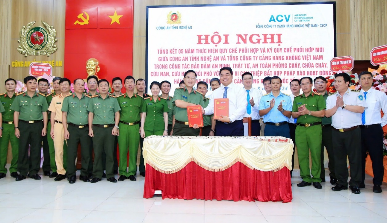 A group of people in uniform standing in front of a red and white bannerDescription automatically generated