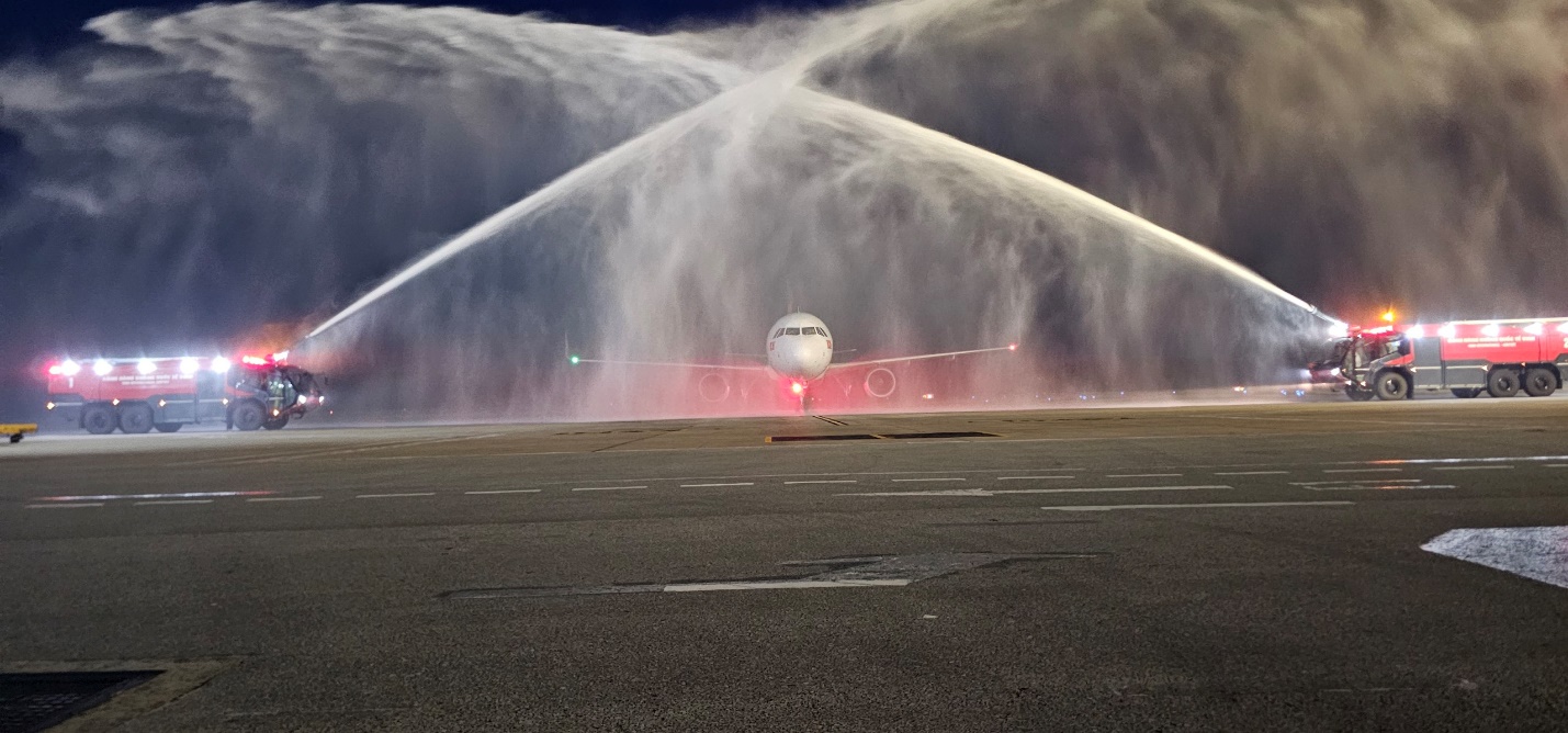 A jet plane spraying water on a runwayDescription automatically generated