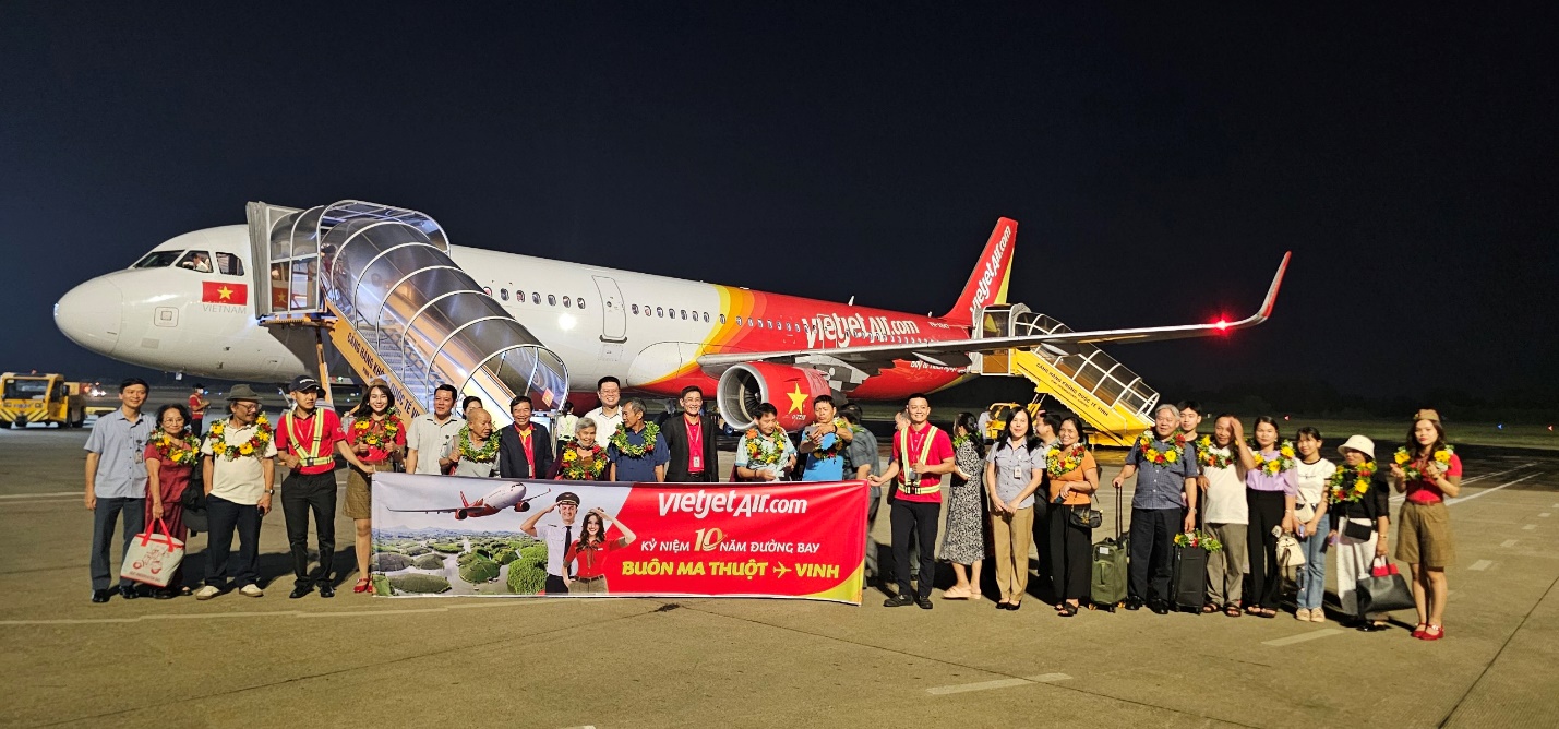 A group of people standing in front of an airplaneDescription automatically generated